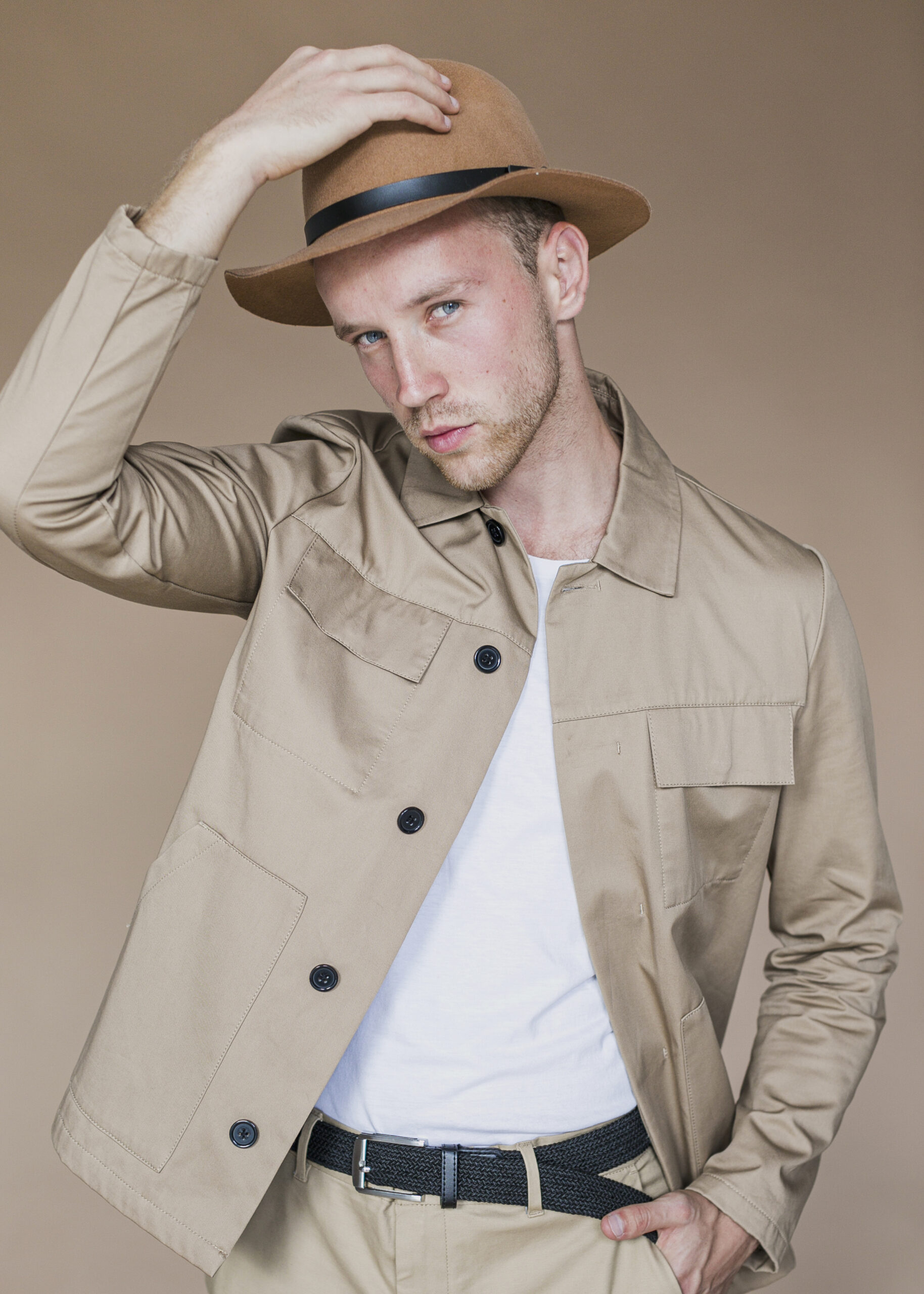 sympathetic-man-with-hat-brown-background